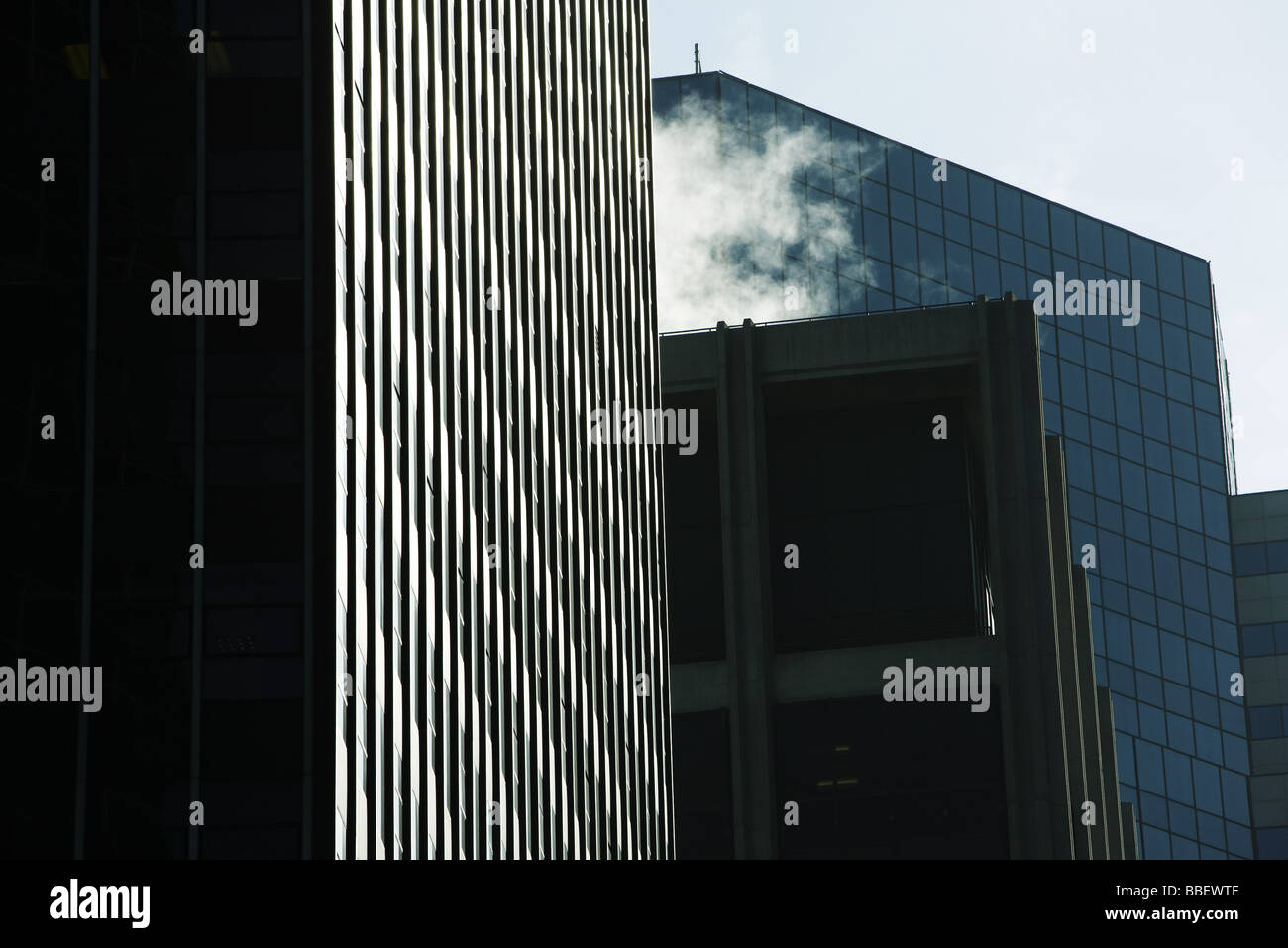 High-Rise Bürohaus nebeneinander, Dampf Dampf wogenden vom Dach, niedrigen Winkel Ansicht Stockfoto