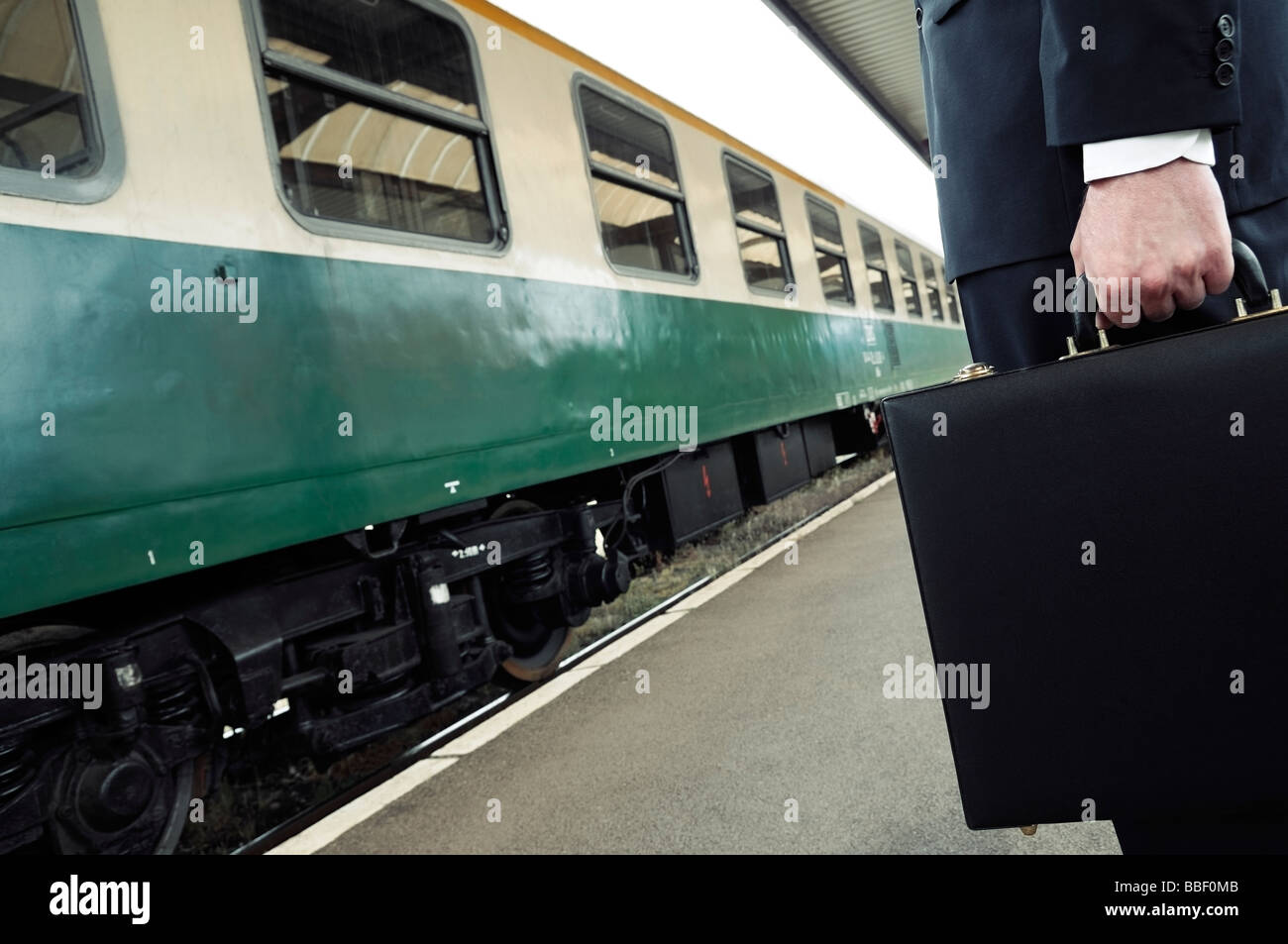 Geschäftsmann, eine Aktentasche, stehend auf einem Zug Station Plattform niedrig halten Stockfoto
