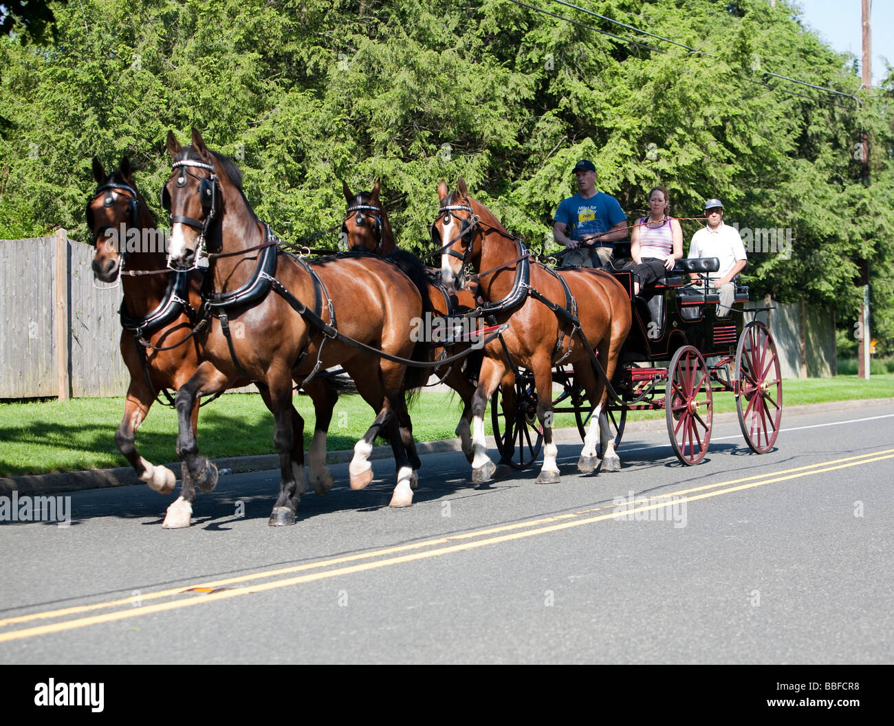 Einen offenen Wagen mit drei Personen, die von vier Pferden gezogen