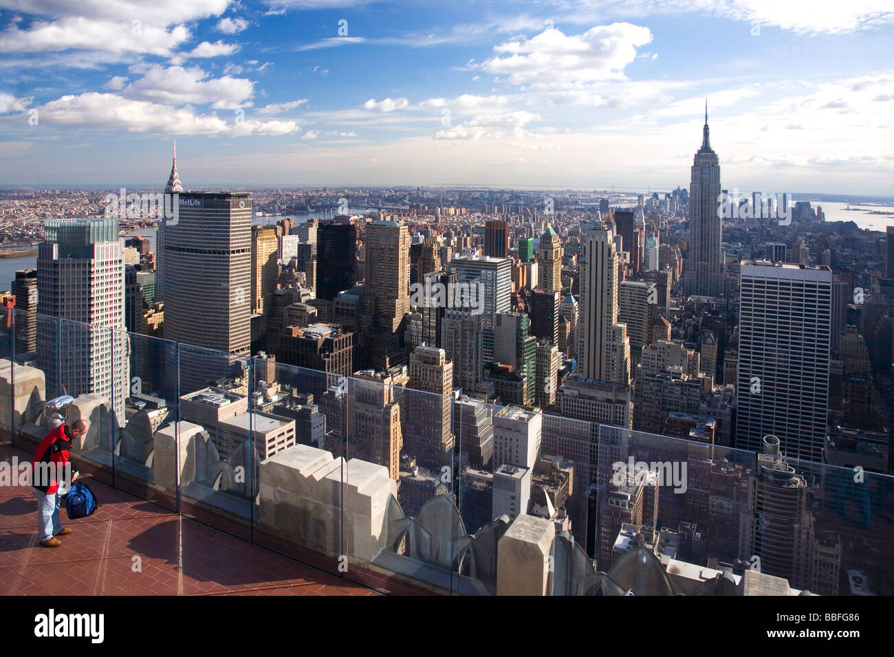 Frau genießt die Aussicht vom Dach des Rock Rockefeller Buildings über Manhattan in Richtung Empire State Building New York City NYC USA Stockfoto