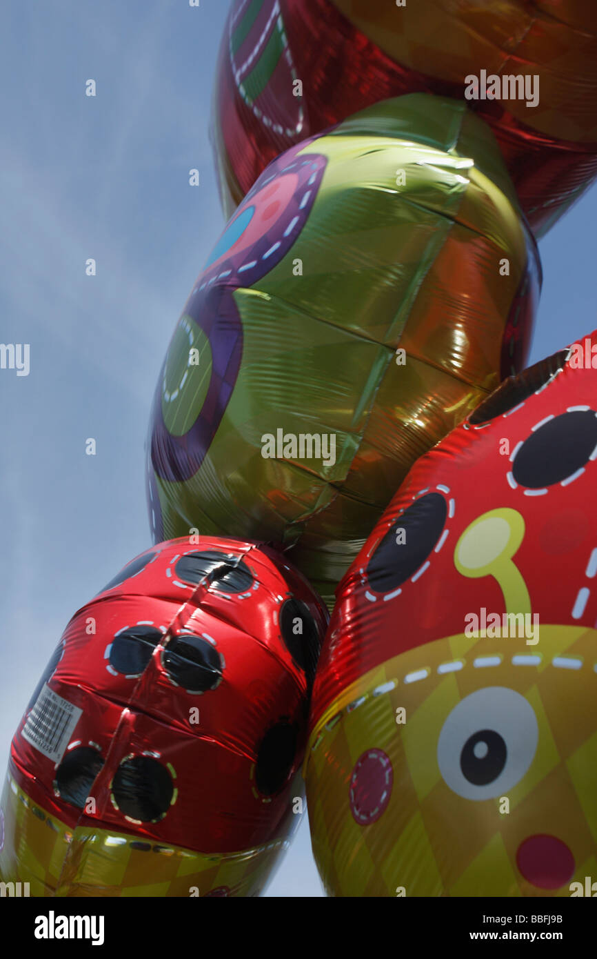 Happy Birthday mit lächelnden Gesichtsballons, die vor einem blauen Himmel schwebten, Nahaufnahme von unten aus flachem Winkel Vorderansicht Niemand vertikal in den USA hochauflösend Stockfoto