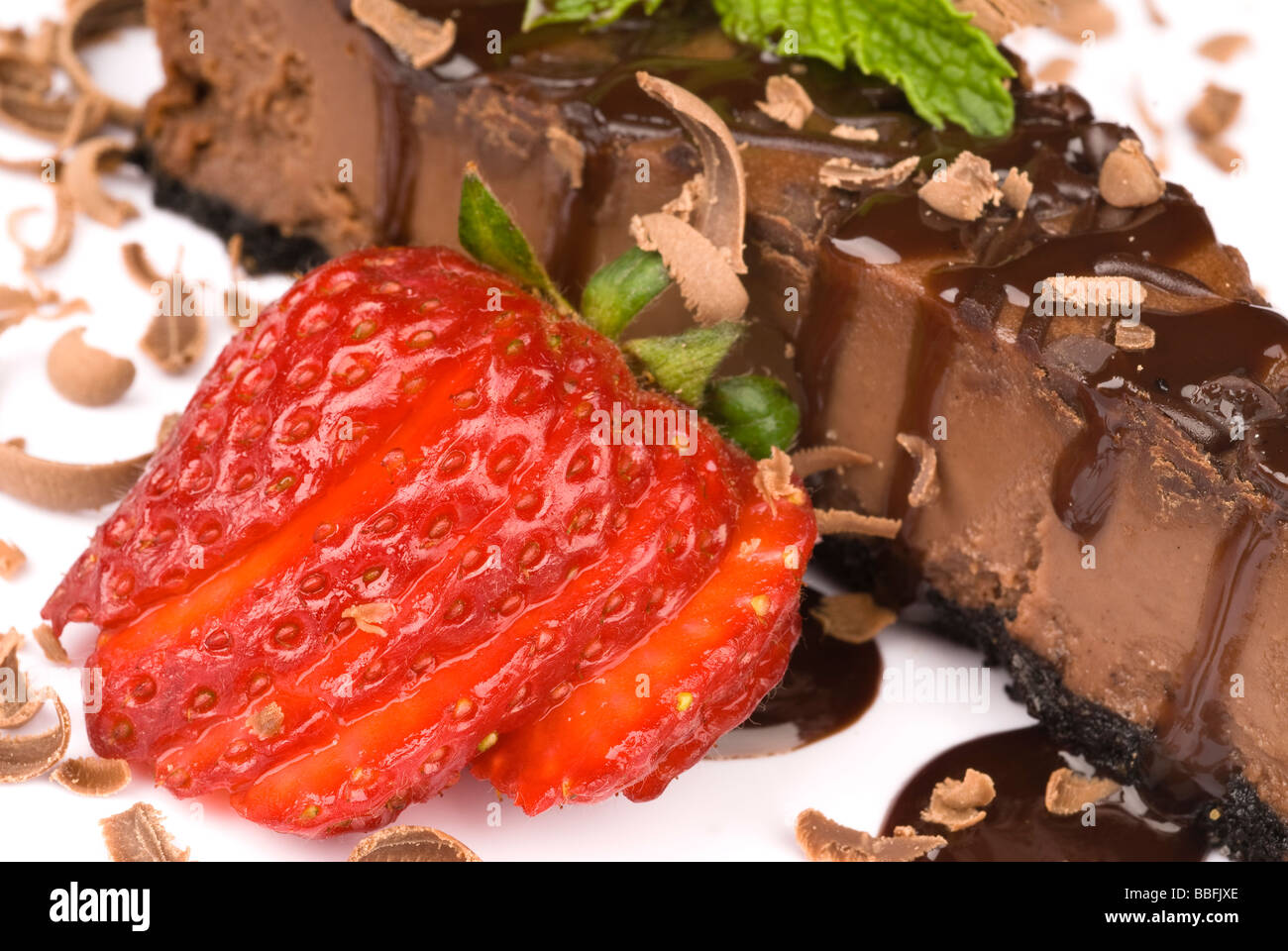 Eine Nahaufnahme ein Stück Schokolade Käsekuchen mit einer frischen Erdbeere garnieren Stockfoto