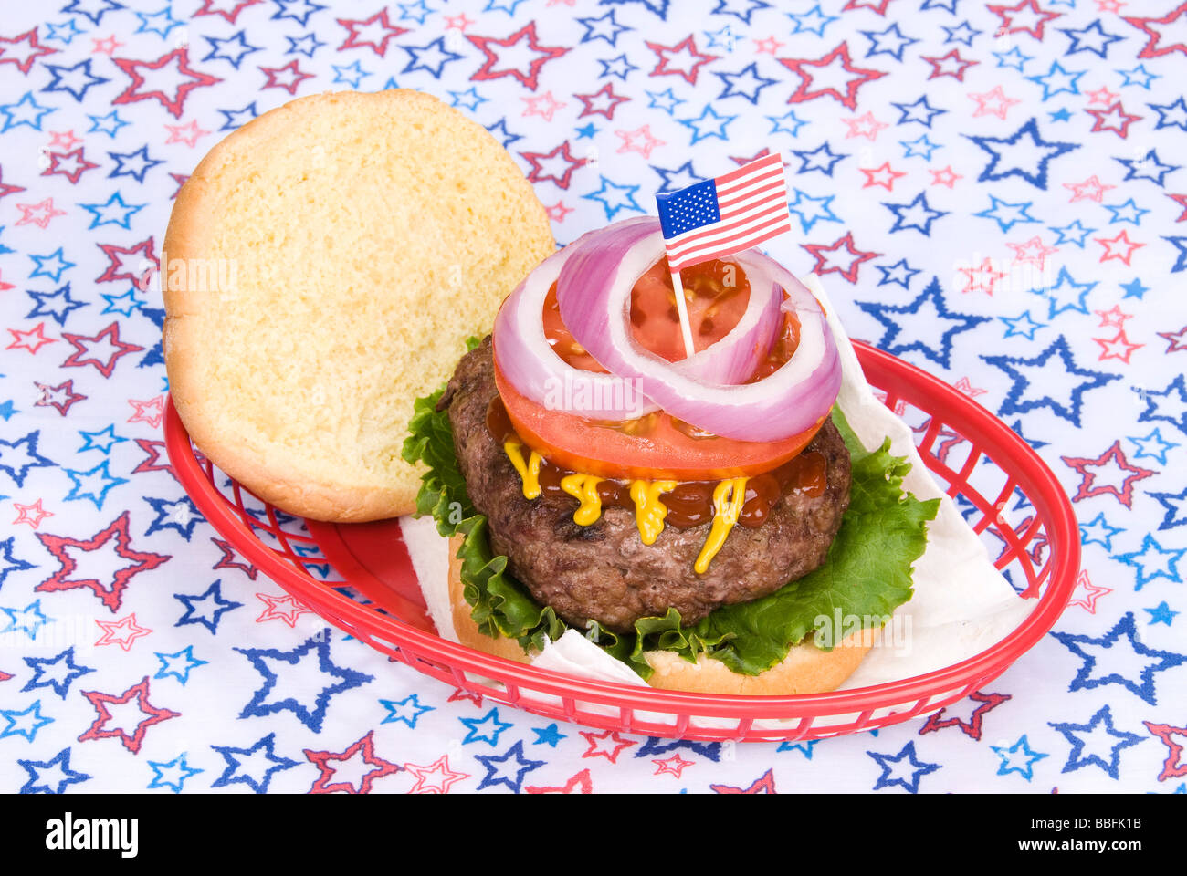 Einen dicken saftigen Hamburger in einem Korb mit einem vierten Juli Thema Stockfoto