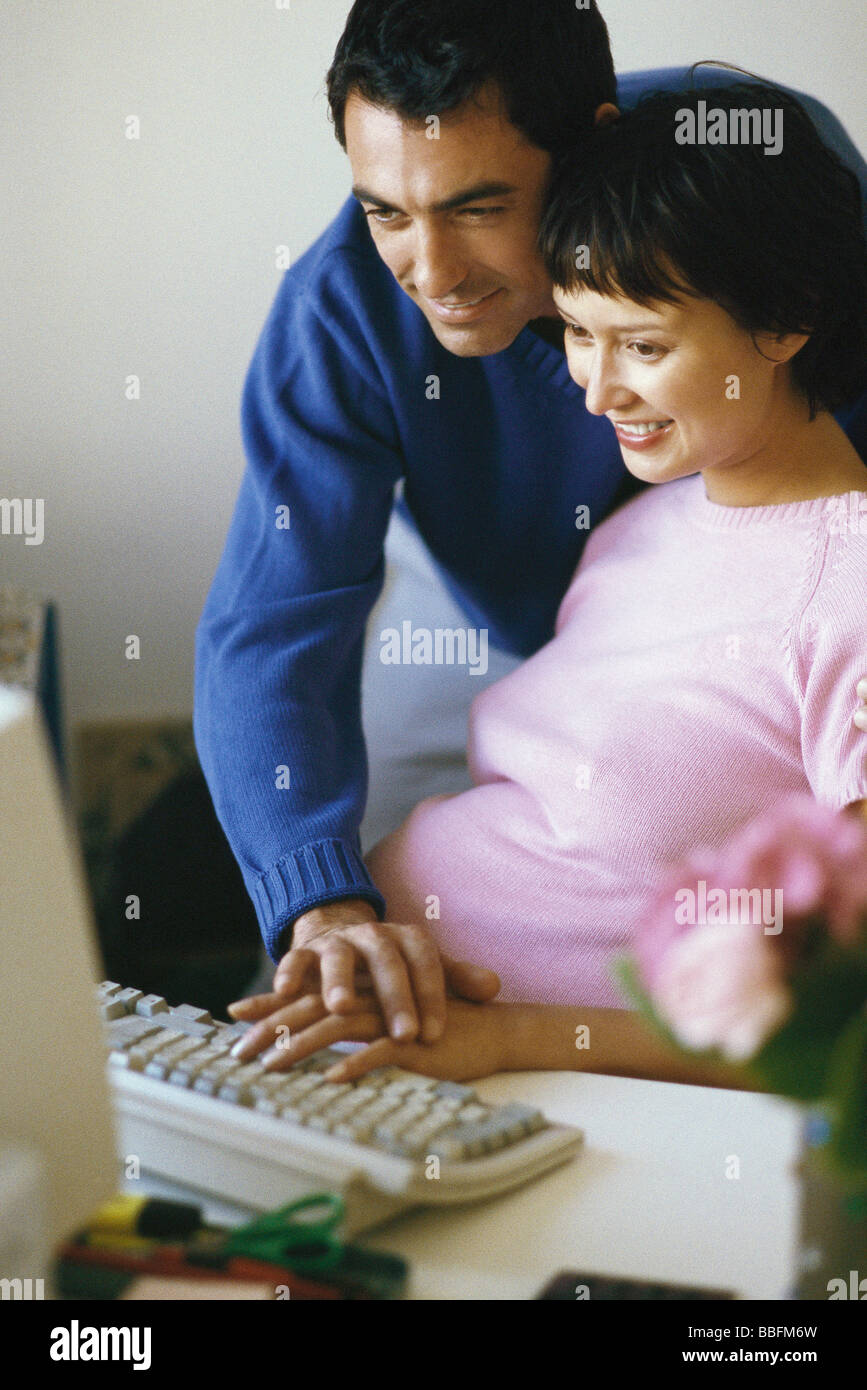 Paar mit Desktop-Computer zusammen, Hand des Mannes ruht auf zarte Frauenhand Stockfoto