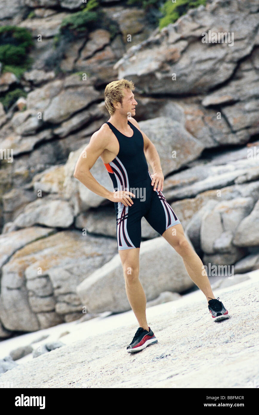 Junger Mann mit Händen auf den Hüften tun Strecken im freien Stockfoto