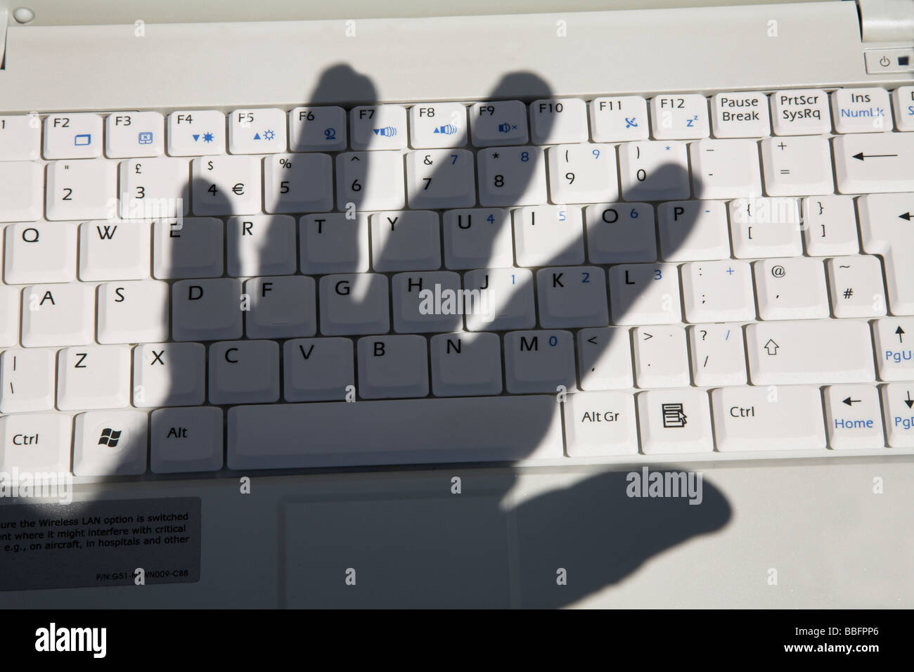 Schatten der Palme der Hand über die Computertastatur. Stockfoto