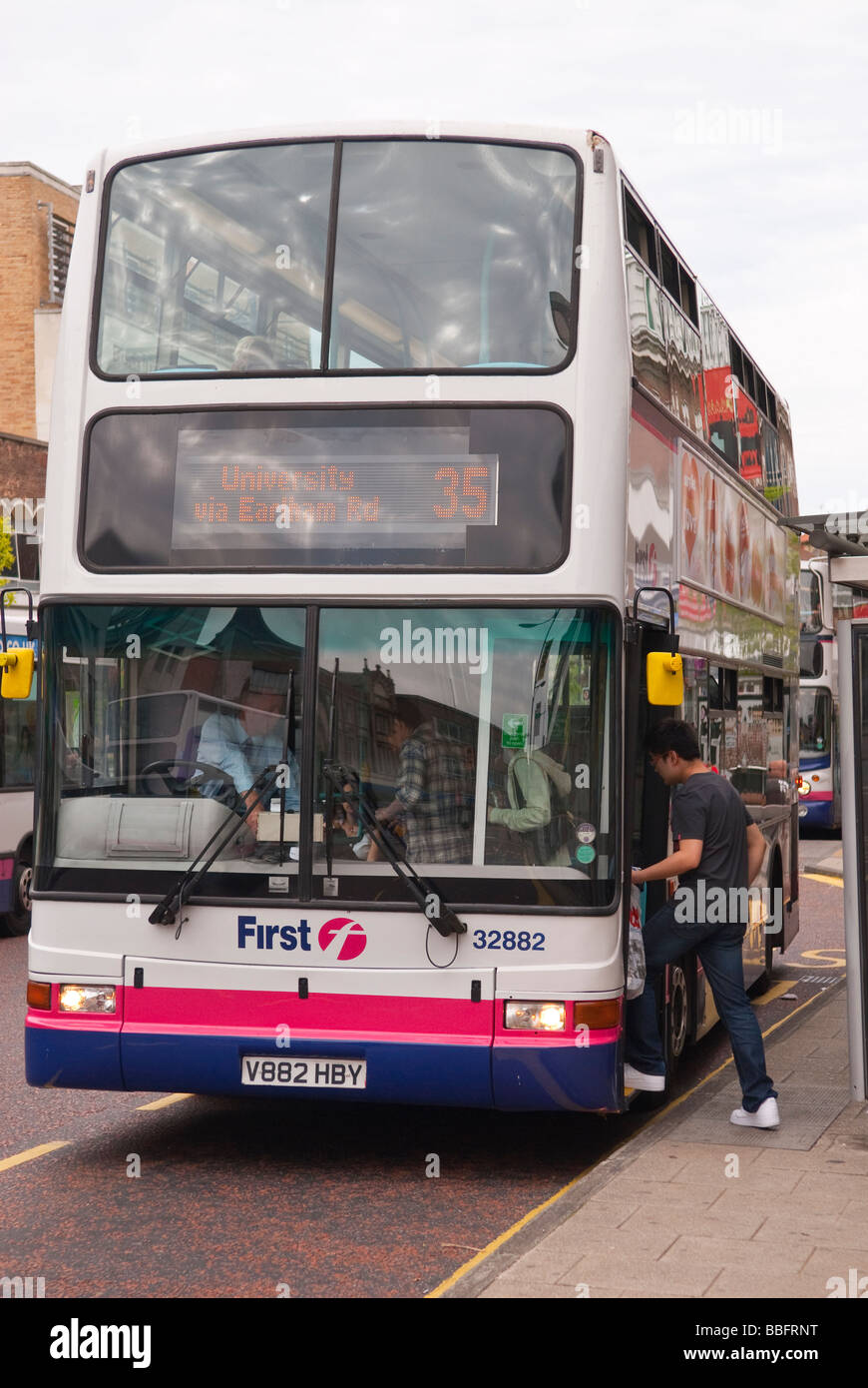 Eine Person, die immer auf einen Doppeldecker-Bus in das Vereinigte Königreich an einer Bushaltestelle Stockfoto