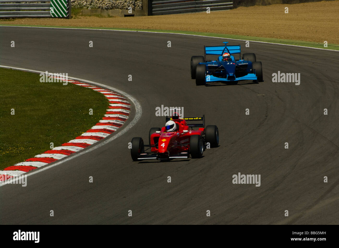 Eine rote Pfeile Formel 1 Rennwagen angetrieben von Chris Woodhouse führt ein blaues Panoz Championship Auto angetrieben von Henk De Boer Stockfoto