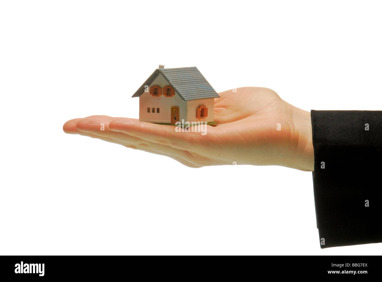 Modell nach Hause stehend auf einer weiblichen Hand, symbolisch für Immobilien Stockfoto