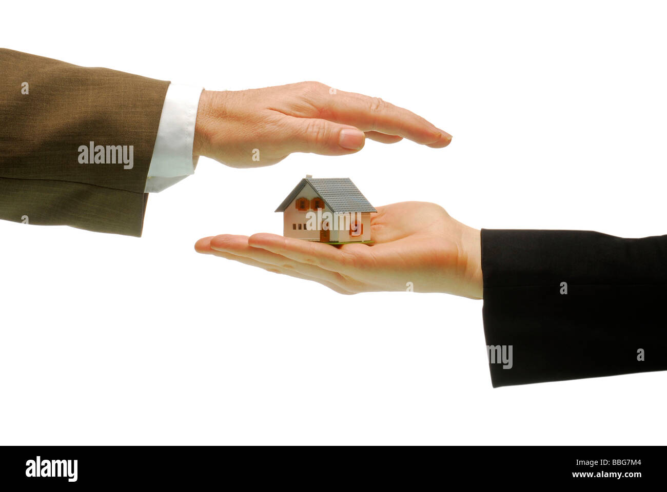 Modell nach Hause stehend auf einer weiblichen Hand, männliche hand oben, symbolisch für Immobilien Stockfoto