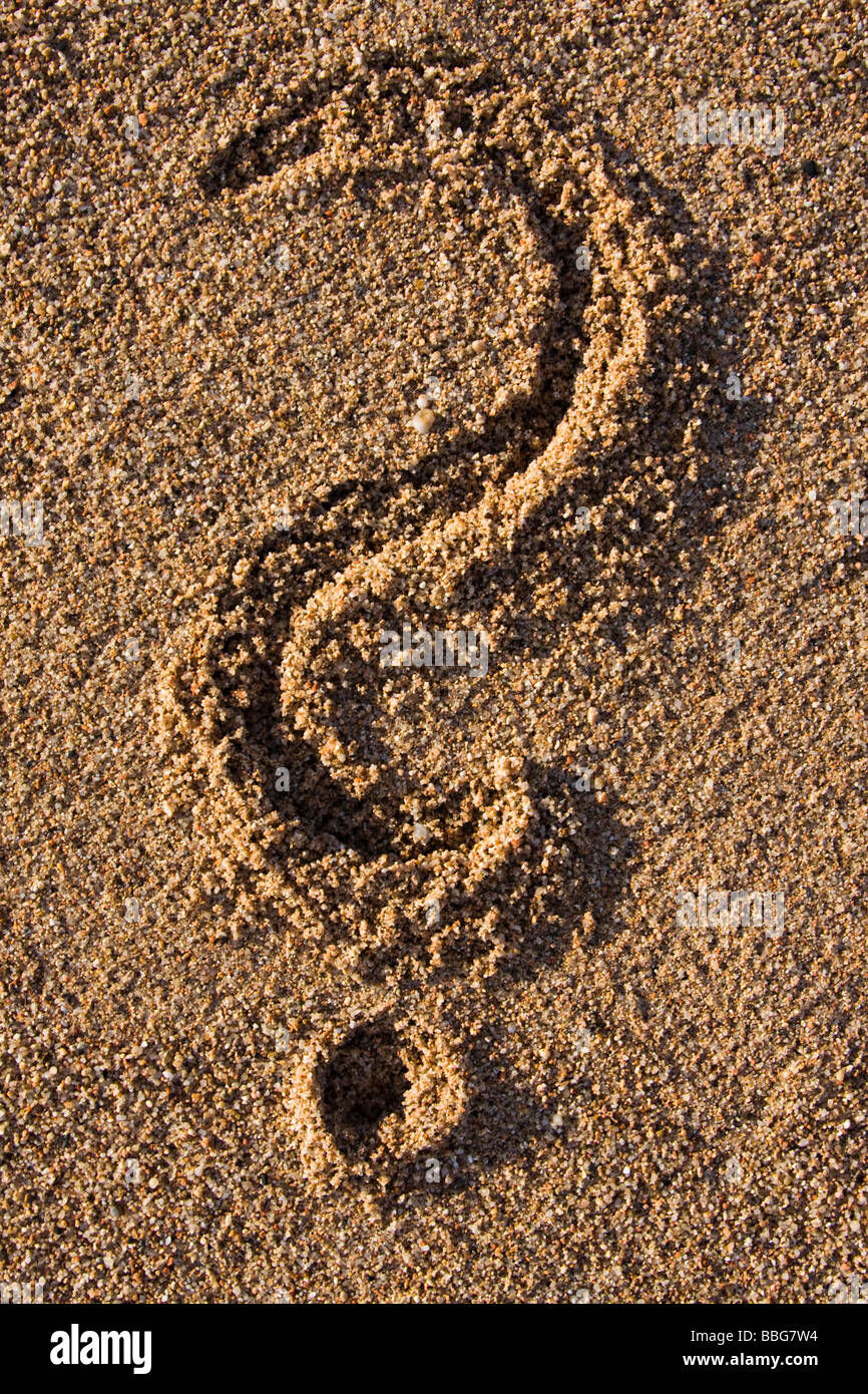 Nahaufnahme von einem Fragezeichen-Zeichen im Sand am Strand Stockfoto