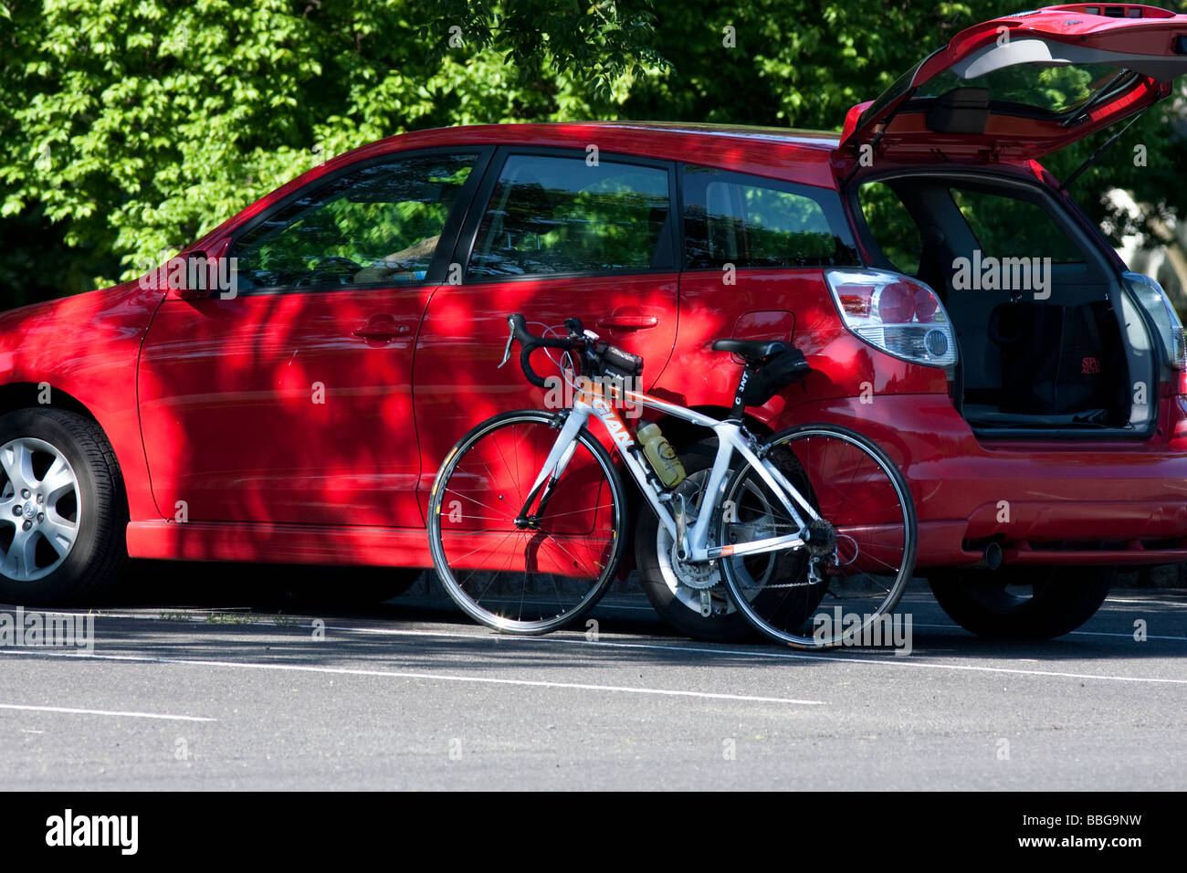 Ein Rennrad ruhen gegen ein Auto mit der Motorhaube Luke öffnen. Stockfoto