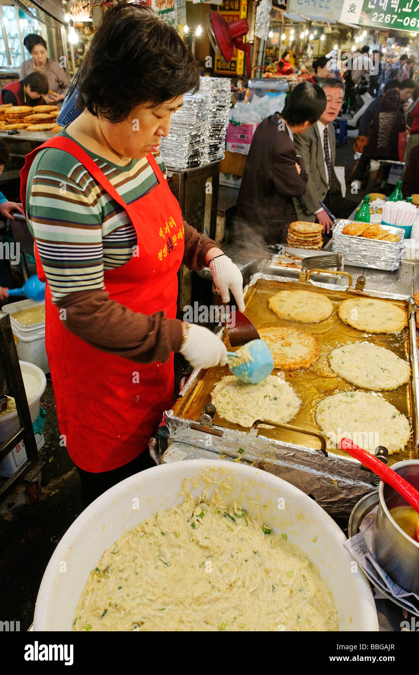 Koreanisches Essen, Frau bereitet gebratene Gemüse Pfannkuchen auf einem Markt in Seoul, Südkorea, Asien Stockfoto