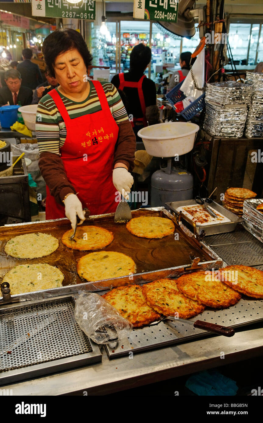Koreanisches Essen, Frau bereitet gebratene Gemüse Pfannkuchen auf einem Markt in Seoul, Südkorea, Asien Stockfoto