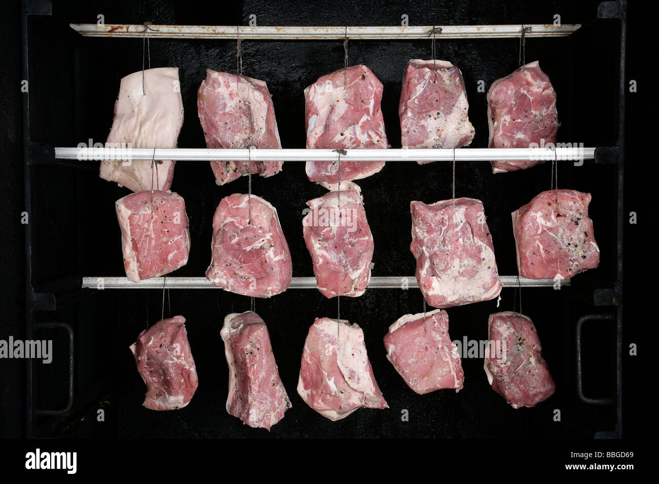 Hängende Schweinefleisch Gelenke in ein Raucher, Produktion der Bayerischen Spezialität Schwarzgeraeuchertes, geräucherter Schinken in einer Metzgerei in Hengers Stockfoto