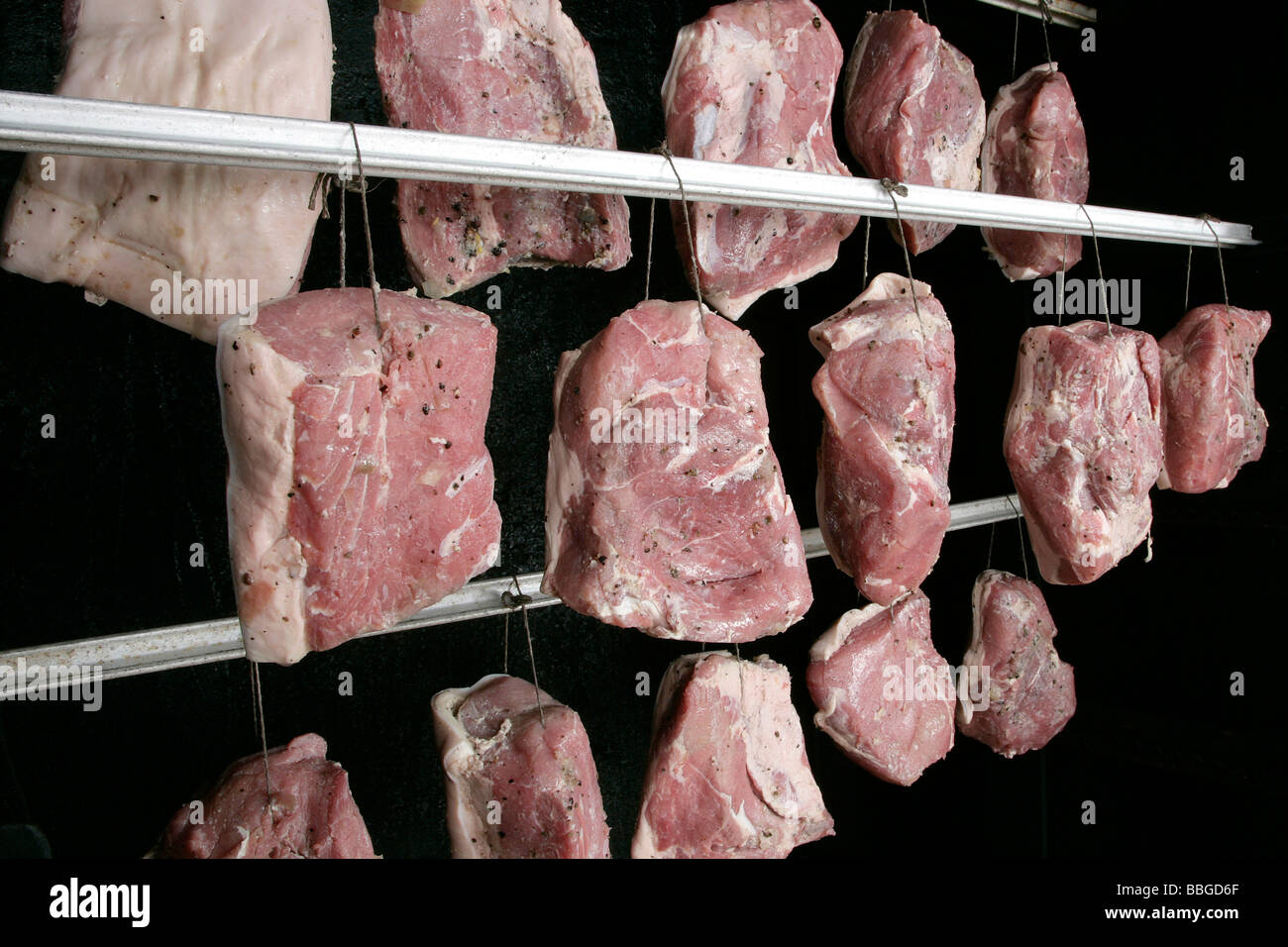 Hängende Schweinefleisch Gelenke in ein Raucher, Produktion der Bayerischen Spezialität Schwarzgeraeuchertes, geräucherter Schinken in einer Metzgerei in Hengers Stockfoto