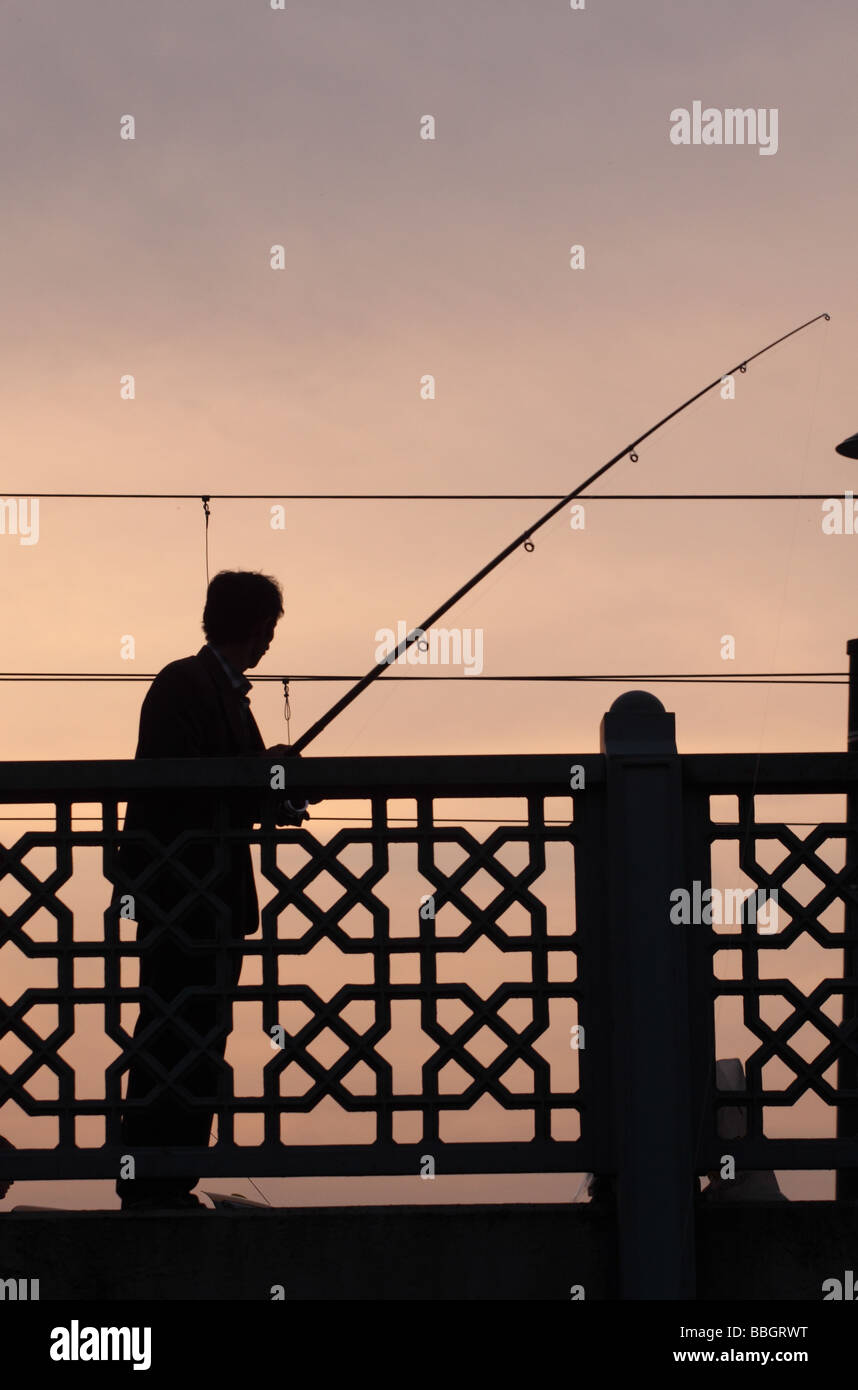 Istanbul Türkei Mann Angeln von der Galata-Brücke in der Eveing Sonnenuntergang Dämmerung Stockfoto