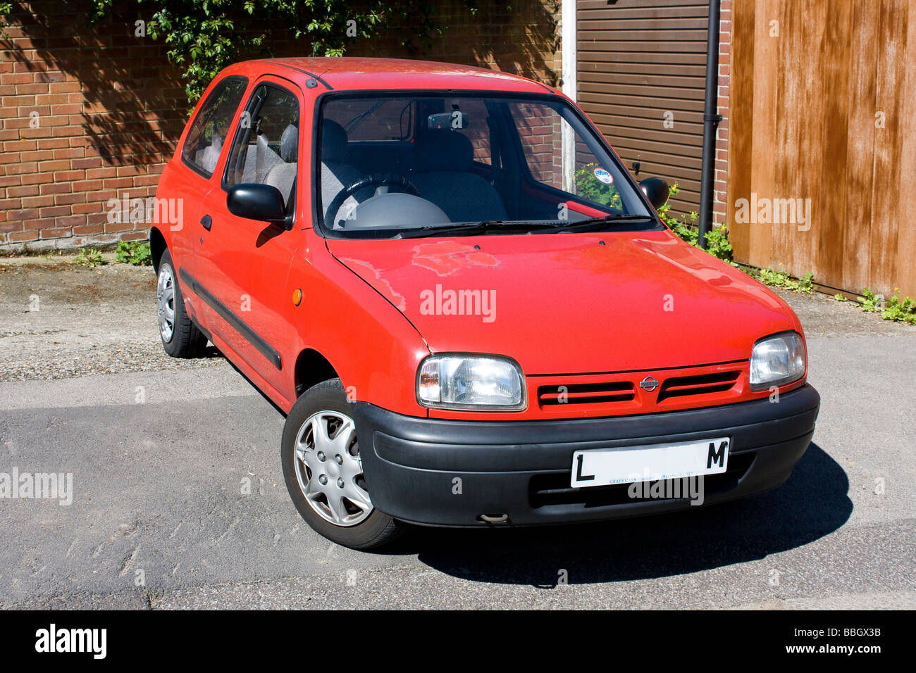 Ein roter Nissan Micra neben der Straße geparkt Stockfoto