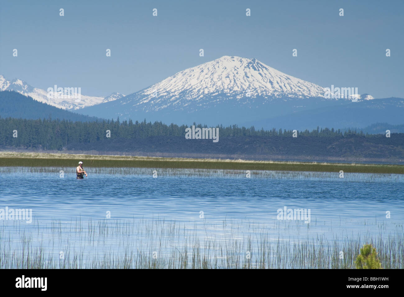 Fischer in Davis Lake mit Mount Bachelor in weiter Ferne Stockfoto