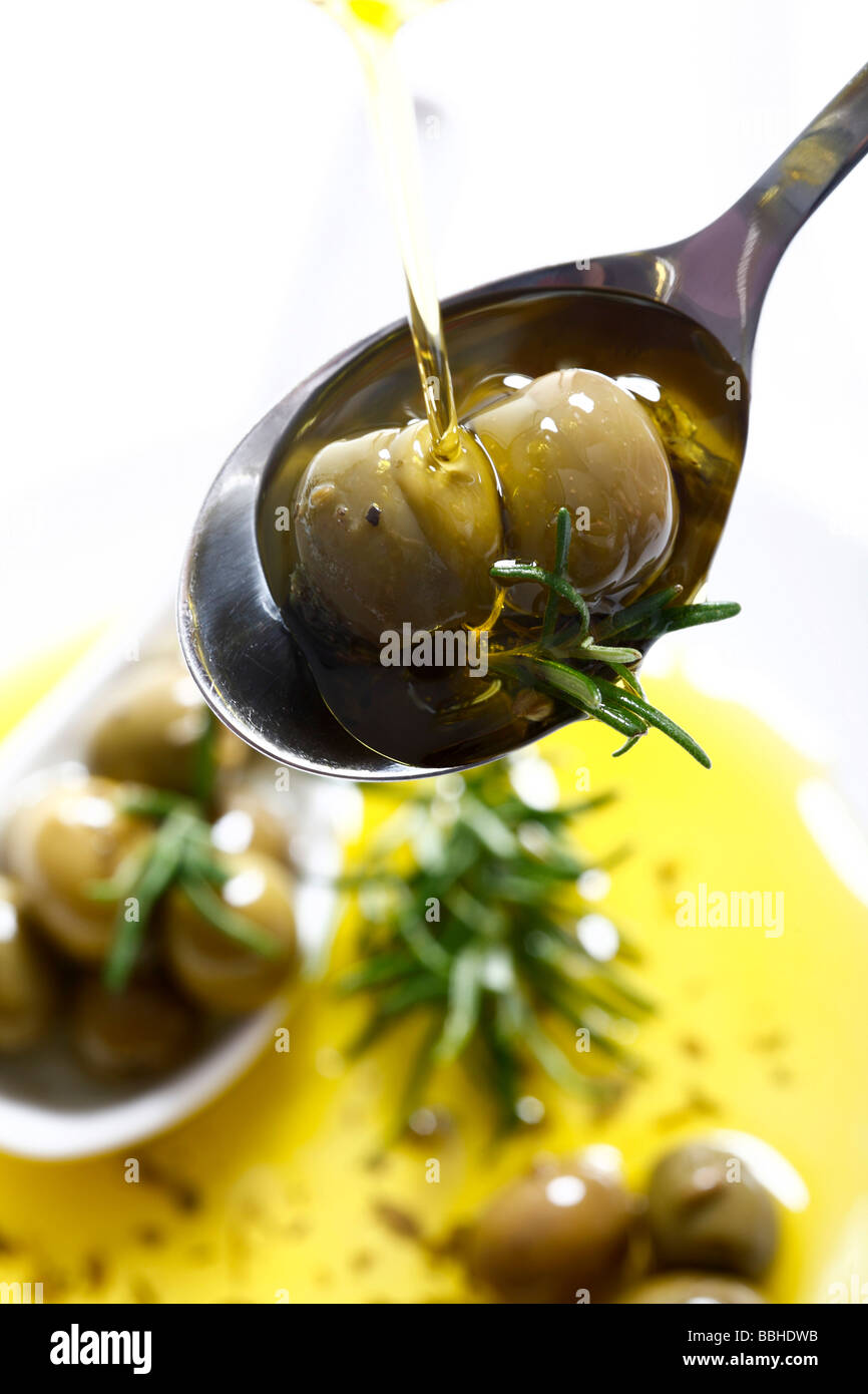 Oliven und Thymian auf einem Löffel, bedeckt mit Olivenöl Stockfoto