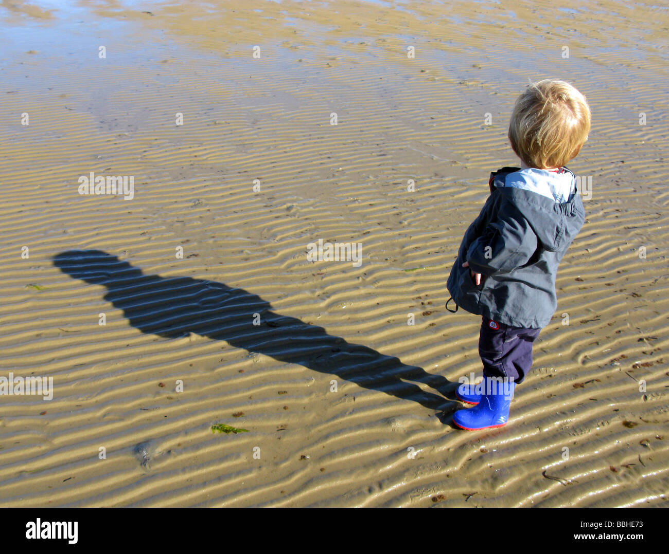Junge allein am Strand Blick nach hinten Stockfoto