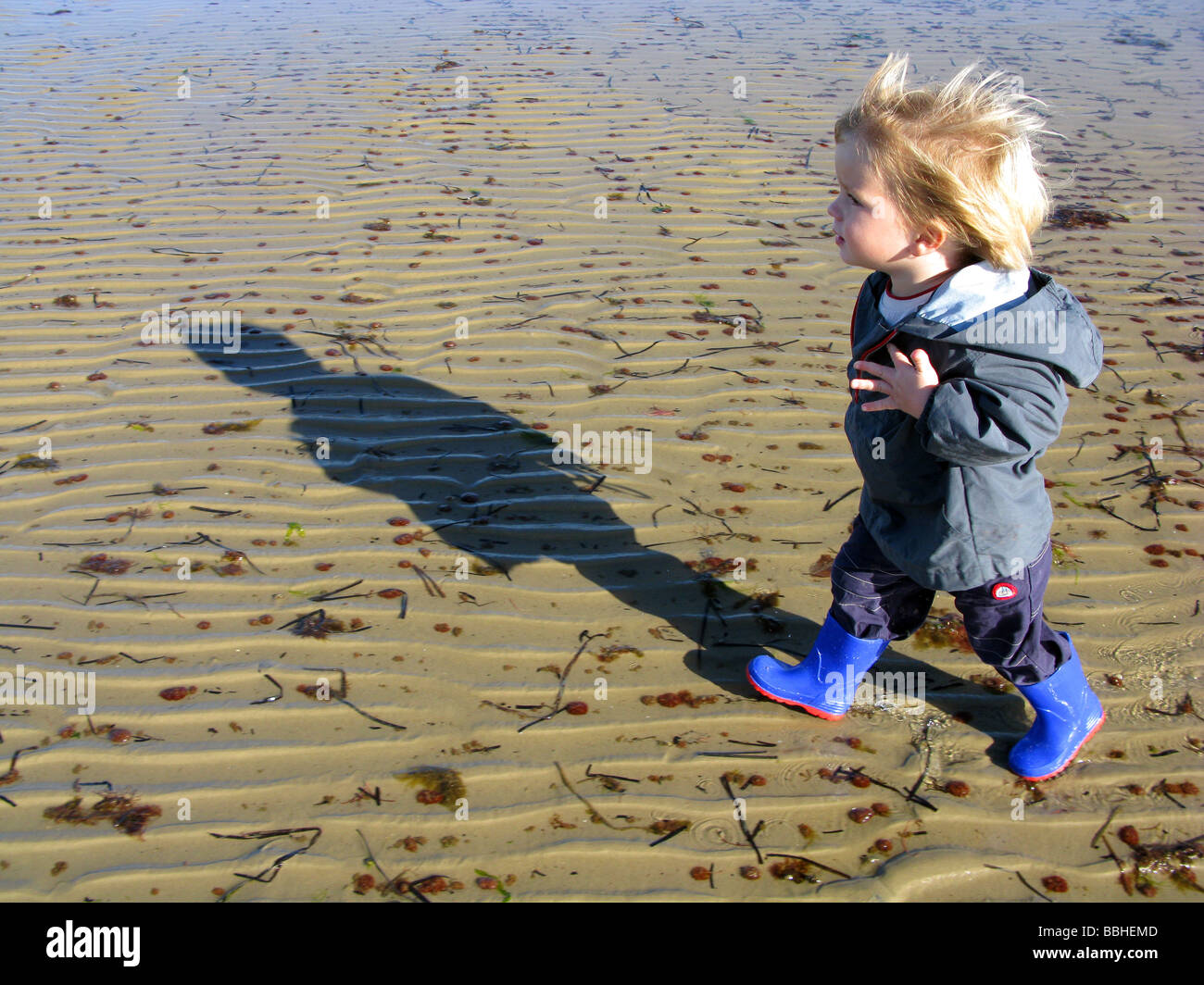 Junge allein am Strand zu Fuß Stockfoto