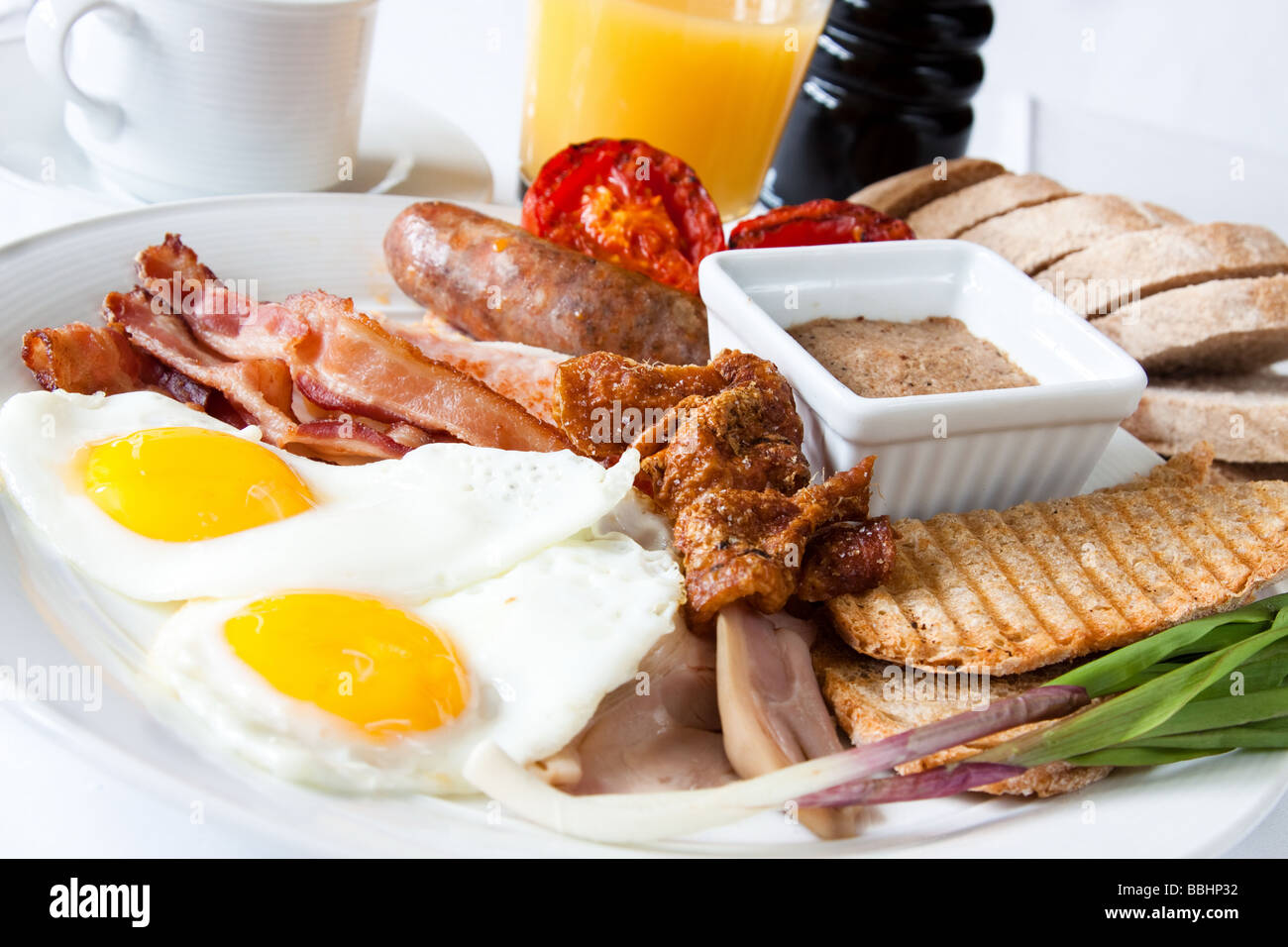 Frühstück mit Spiegeleiern Pinque Wurst doppelt geräucherter Speck Schinken Creton Pilze und Ahorn Grieben. Stockfoto