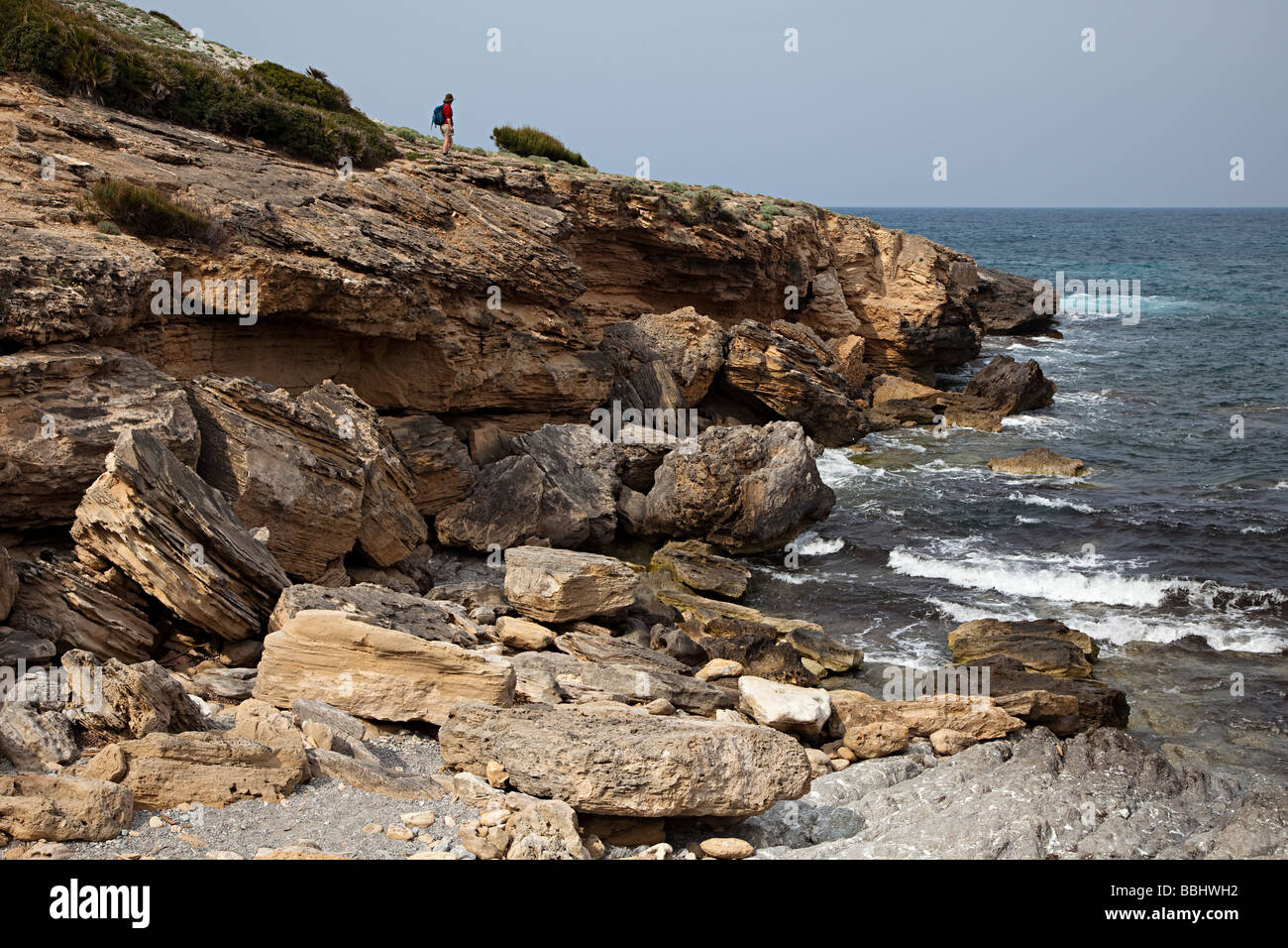 Frau Backpacker auf felsigen Landzunge an der Ostküste von Mallorca Spanien Stockfoto