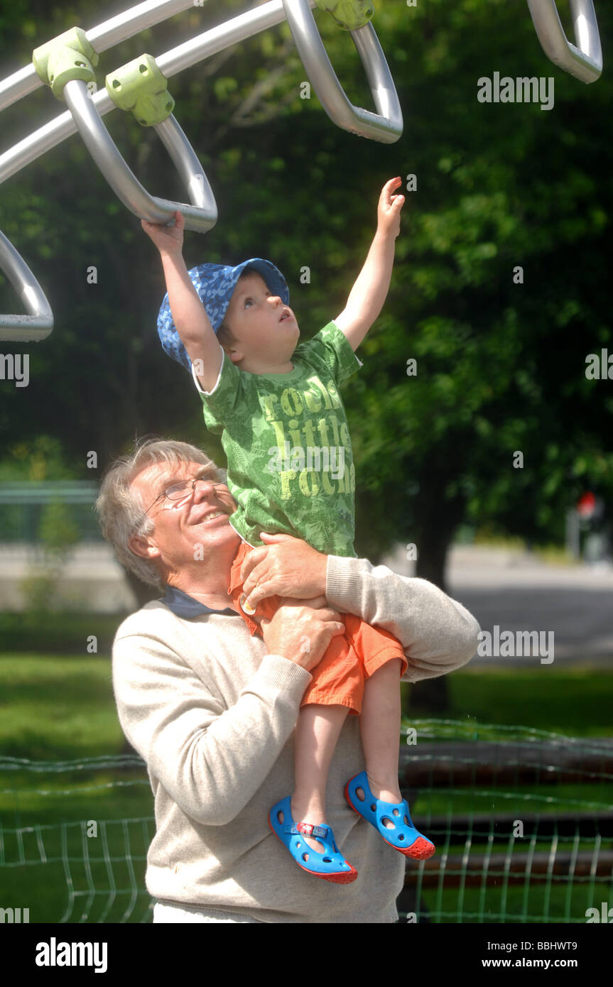 Großvater-Enkel auf einem Spielplatz zu helfen Stockfoto