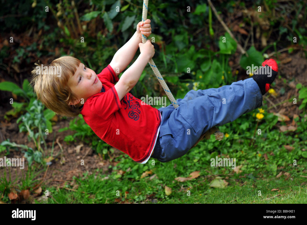 Junge auf einem Seil schwingen, schwingen an einem Seil Kind Stockfoto