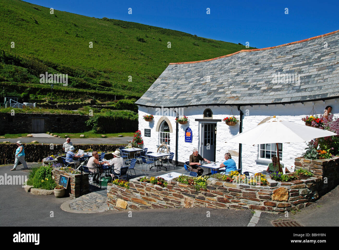 Touristen sitzen vor einem Café in der Nähe von Hafen von Boscastle, Cornwall, uk Stockfoto