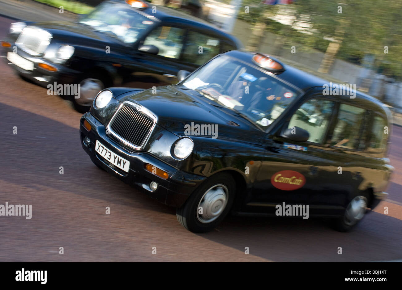 Zwei Londoner Taxis fährt entlang der Straße Stockfoto