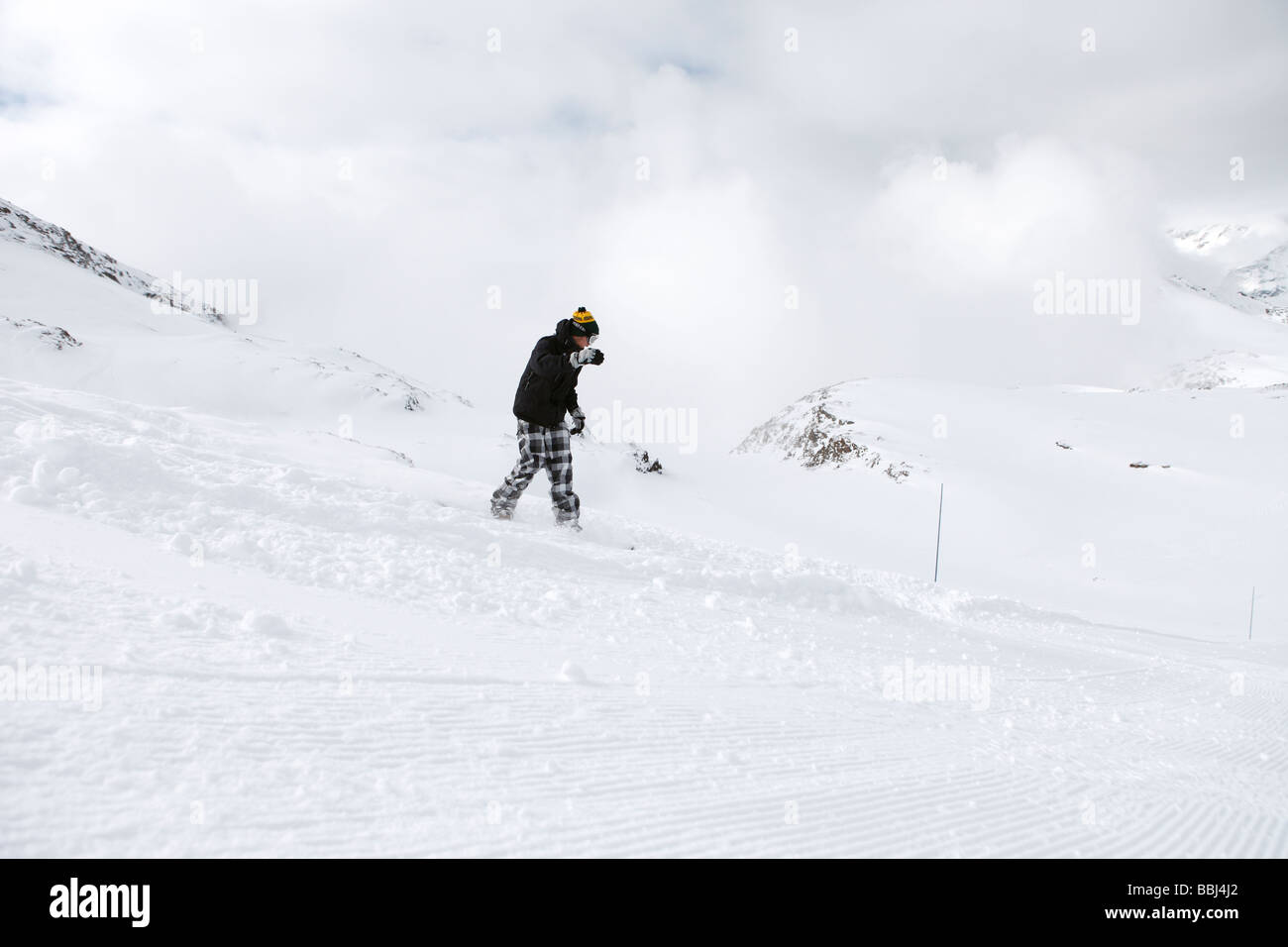 Snowboarder genießt den frischen Schnee am Rand der Piste im Skigebiet Les Deux Alpen, Alpen, Frankreich Stockfoto