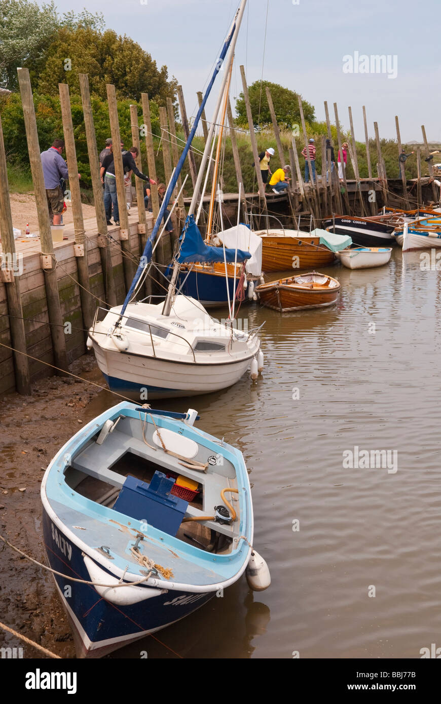 Boote am Hafen Blakeney Zeitpunkt Blakeney North Norfolk mit Menschen Verdrehungen im Hintergrund Stockfoto