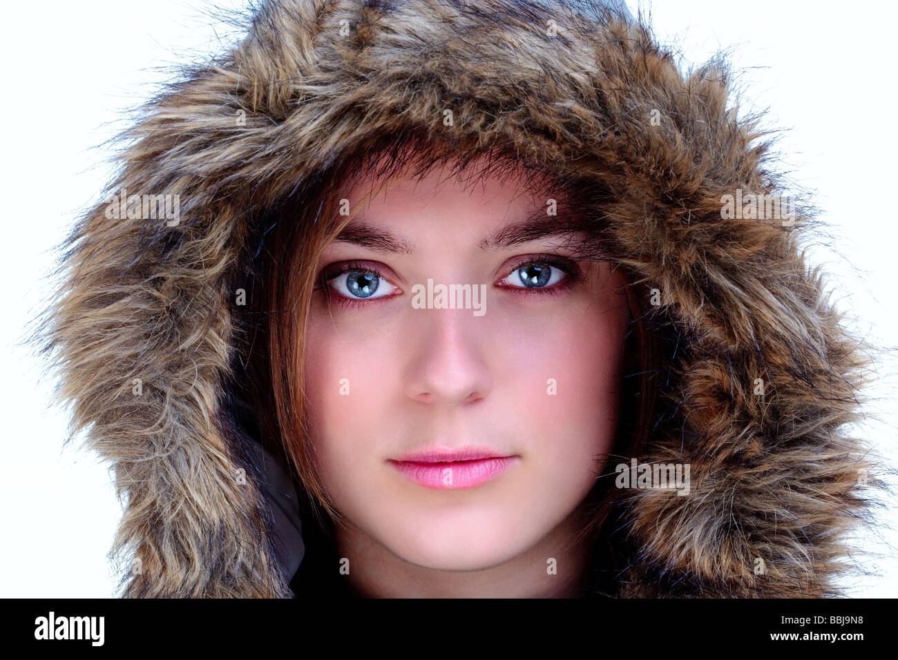 Eine Frau trägt eine Pelz Kapuze Blick in die Kamera auf einem weißen Hintergrund isoliert Stockfoto