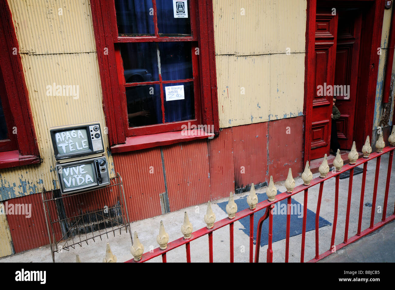 Ein Junge späht heraus hinter einer Tür in Valparaiso. Stockfoto