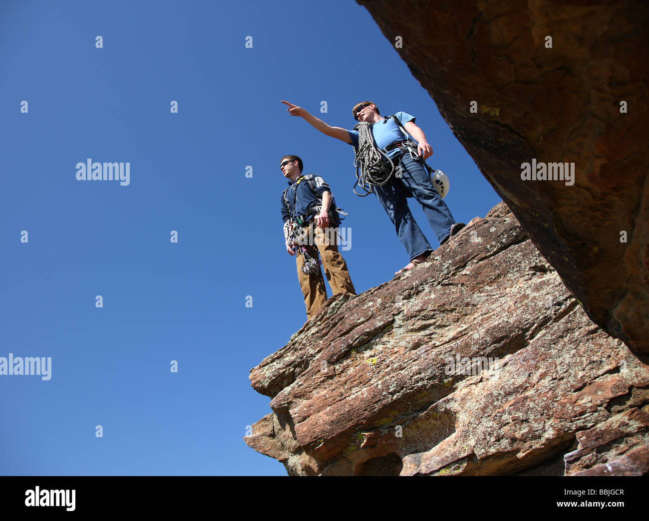 Zwei Kletterer auf Felsvorsprung stehend Stockfoto