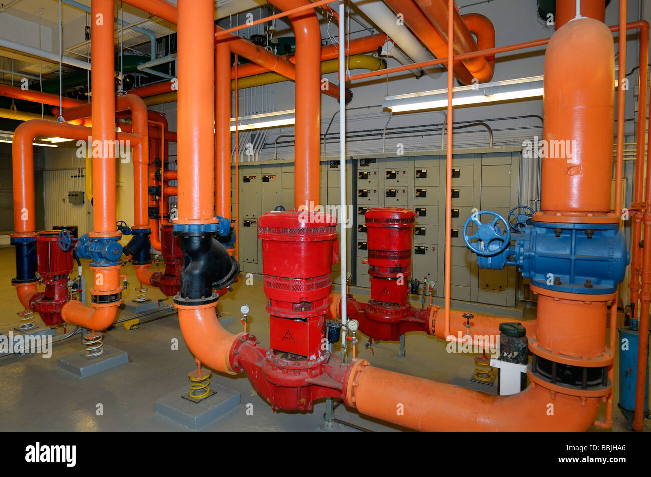 Elektrische Heizung Steuerung und orange Wasserleitungen im Heizungsraum eines Hochhauses Bürogebäude Toronto Stockfoto