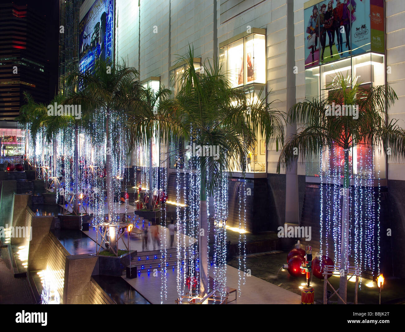 Wie von Zauberhand beleuchtet Palm bewaldeten Gehweg an der Siam Paragon Shopping Mall, Siam Square, Bangkok, Thailand. Stockfoto