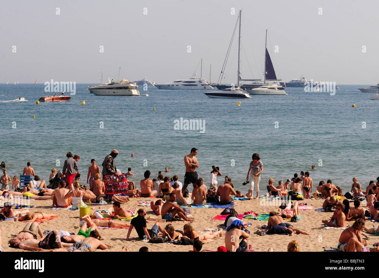 Der Hauptstrand im Zentrum von Cannes, Côte d ' Azur, während das berühmte Filmfestival (siehe viele Yachten im Hintergrund) Stockfoto