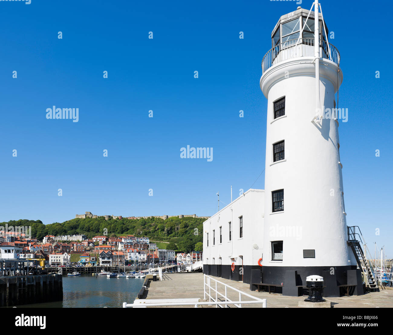 Der Leuchtturm und der Hafen mit dem Schloss hinter Scarborough, Ostküste, North Yorkshire, England Stockfoto