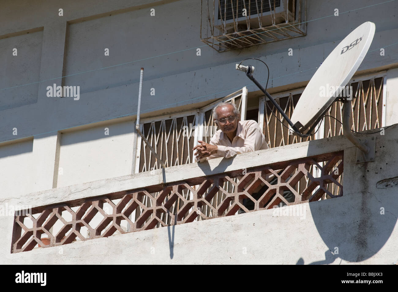 Mann auf einem Balkon mit Satellitenschüssel Quelimane Mosambik Stockfoto