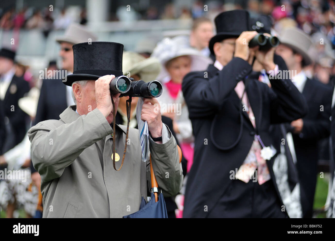 Top Hatted Rennen Gänger beim Epsom Derby nach einem Rennen mit ihrem Fernglas Stockfoto