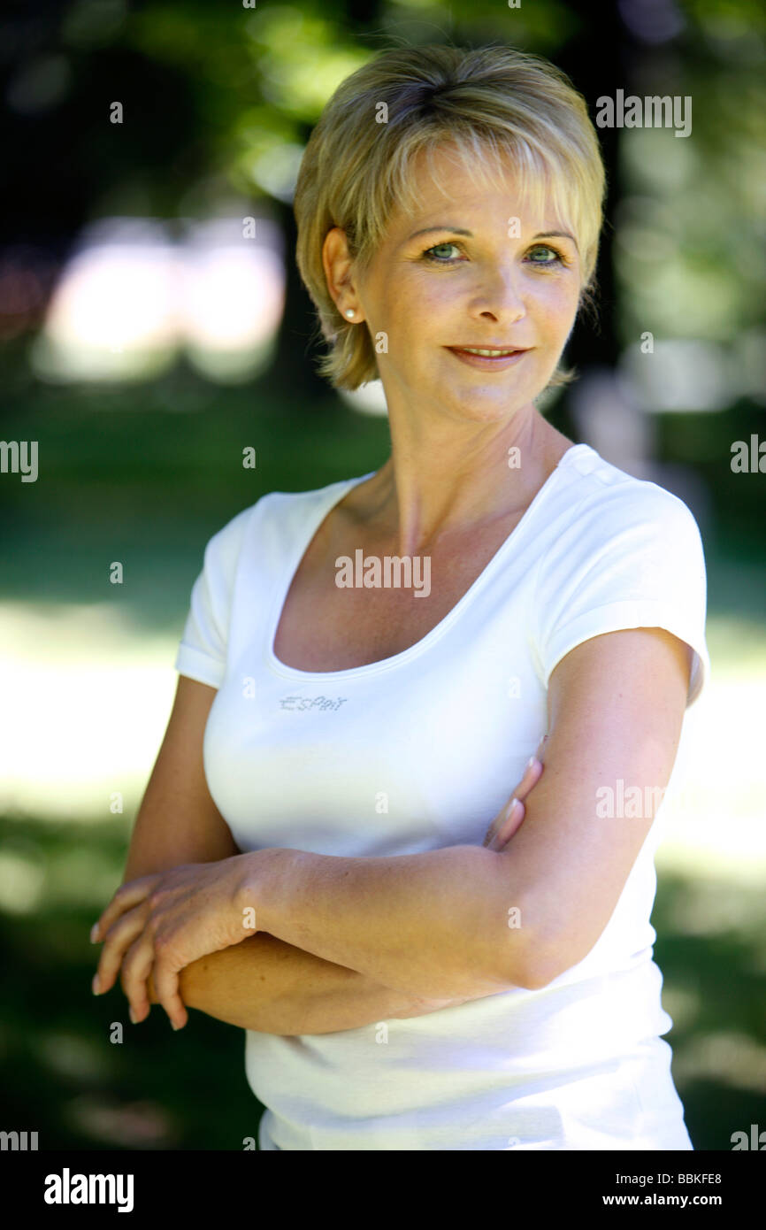 Frau 40 45 Jahre alt lächelnd in die Kamera in einem Garten Stockfoto