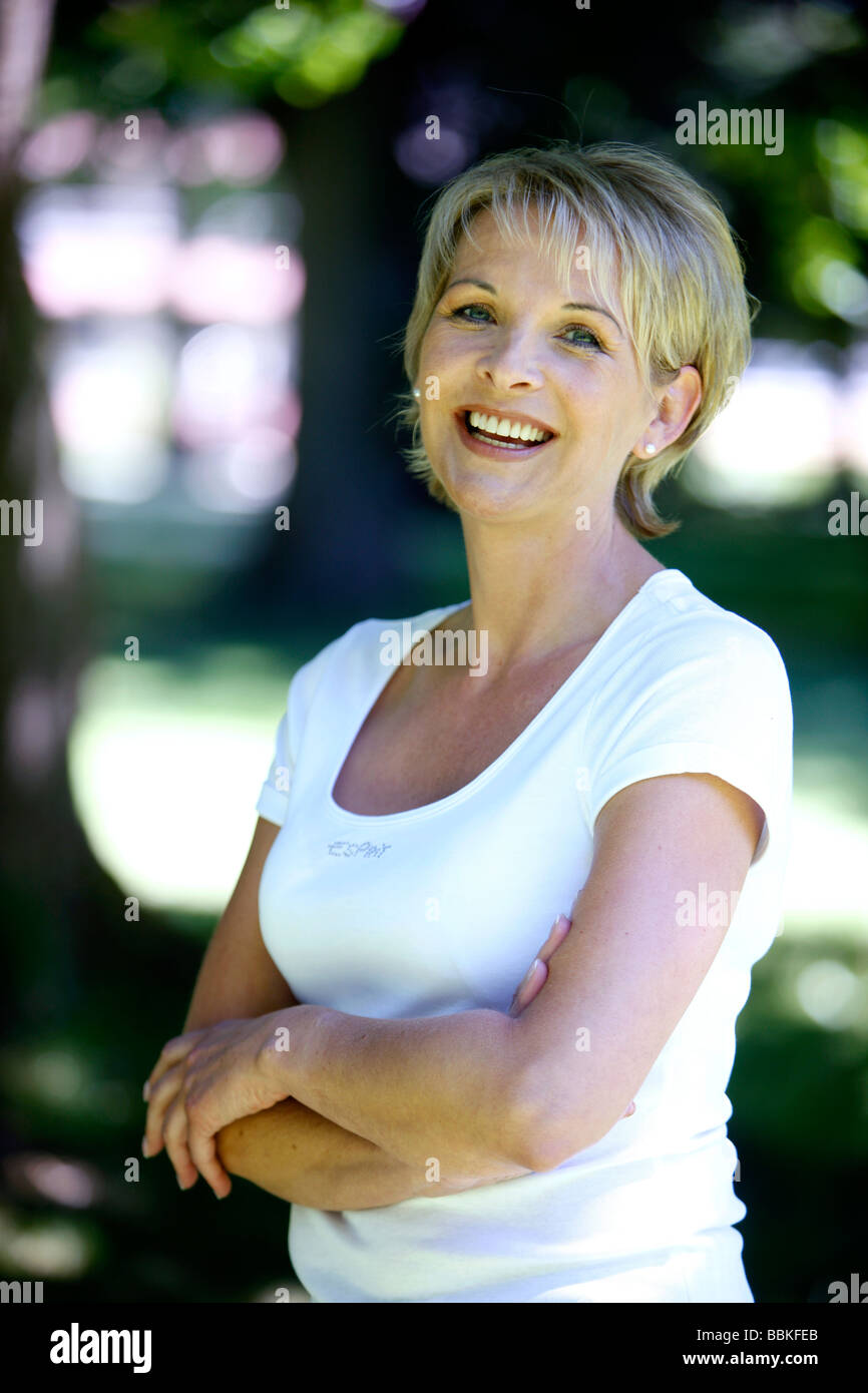 Frau 40 45 Jahre alt lächelnd in die Kamera in einem Garten Stockfoto