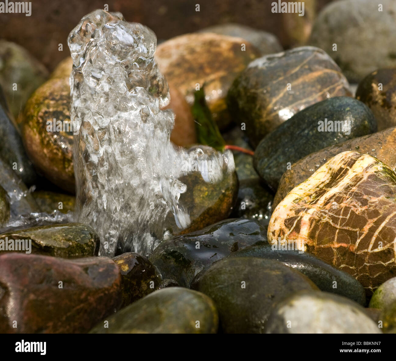 Wasser-Brunnen über Kiesel Stockfoto