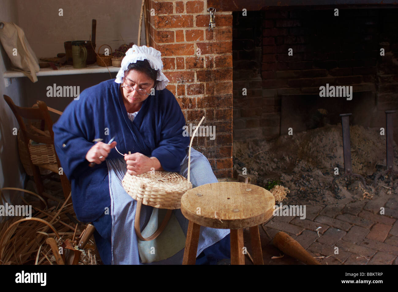 Ein kostümierter historische Dolmetscher webt Körbe an Wythe House Colonial Williamsburg Virginia Stockfoto