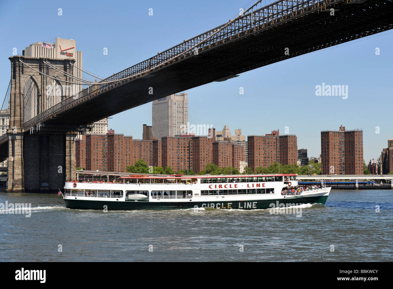 Circle Line Sightseeing-Boot vorbei unter der Brooklyn Bridge Manhattan Skyline im Hintergrund Stockfoto