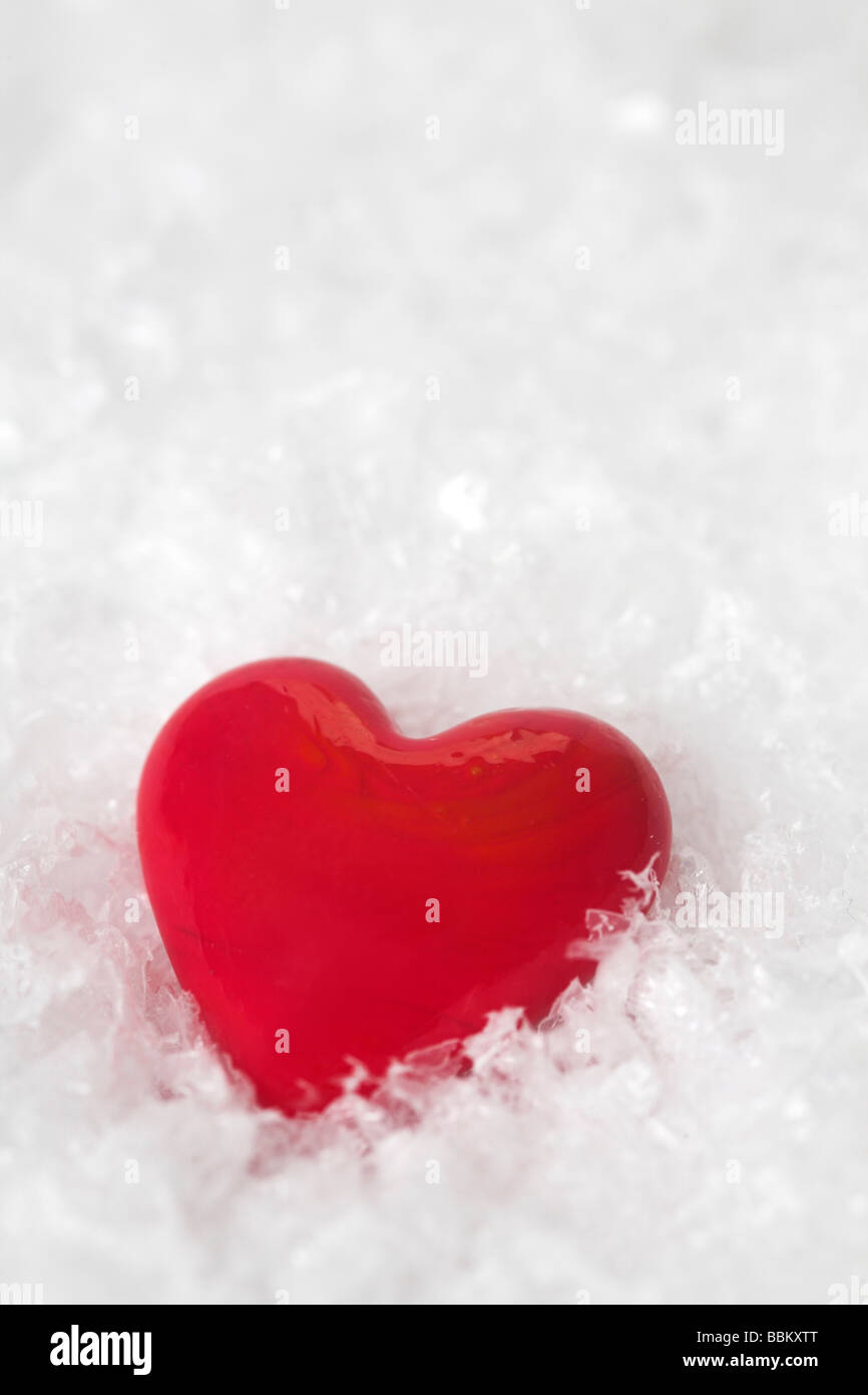 Rotes Herz aus Glas in Kunstschnee gemacht Stockfoto
