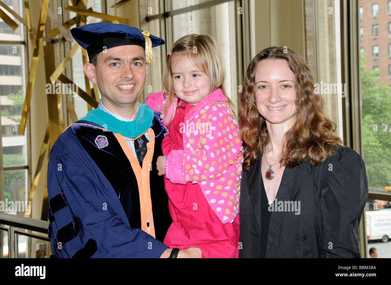 Graduierung Zeremonie Porträt der Absolvent tragen Mütze und Mantel feiert mit seiner Frau und Tochter Stockfoto